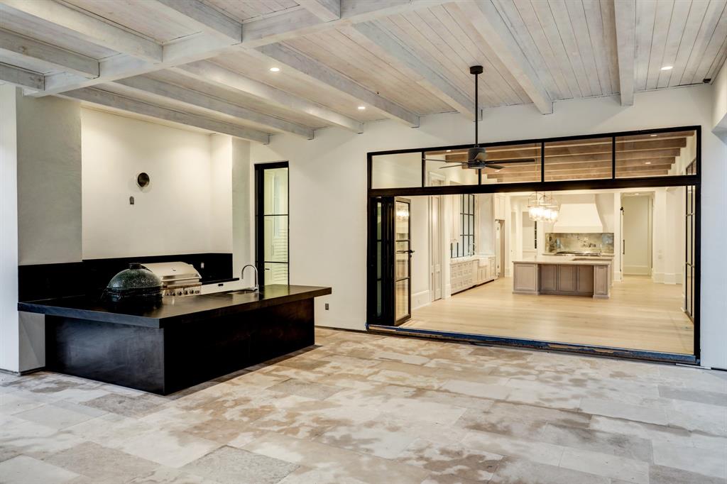 Custom steel and glass folding door opens Breakfast area to the Summer Kitchen and covered loggia area. (Photo by TK Images)