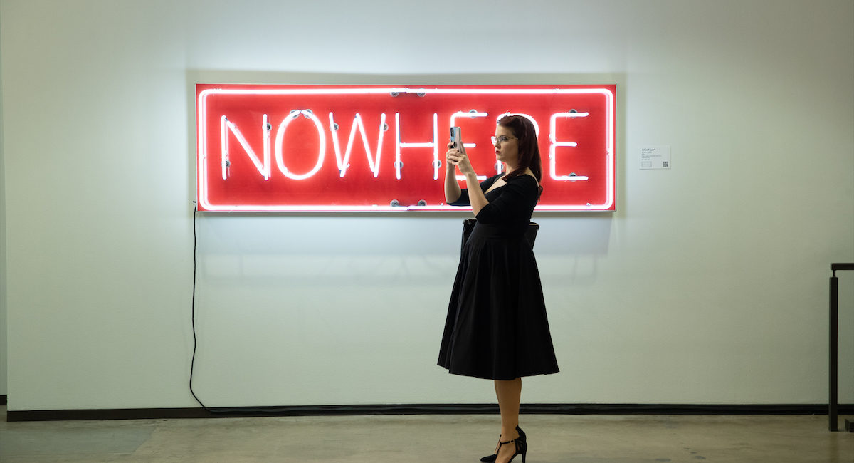 A visitor in front of a neon artwork by Alicia Eggert. Dallas Art Fair Preview, 2021. Credit Exploredinary (Photo by Exploredinary)