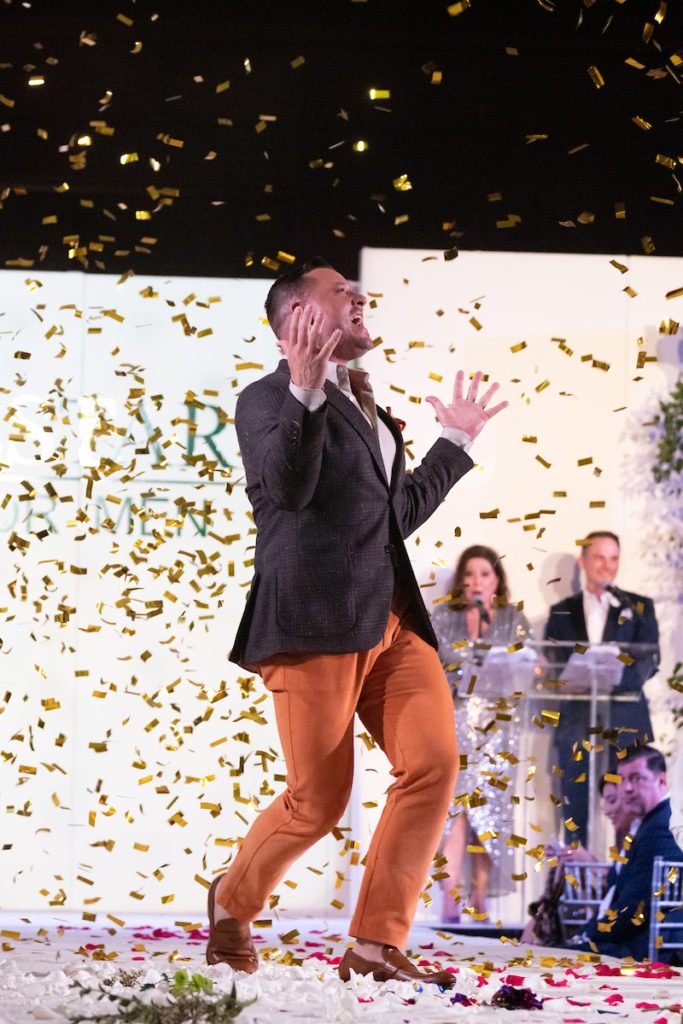 Clayton Katz showered with confetti as he jukes down the catwalk during the Una Notte Italia men's fashion fundraiser. (Photo by Daniel Ortiz)