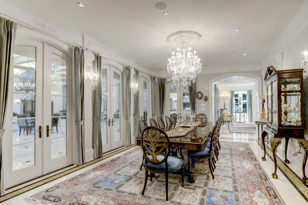 The dining room of the River Oaks Boulevard home opens through French doors to the vast pool room. (Photo by TK Images)