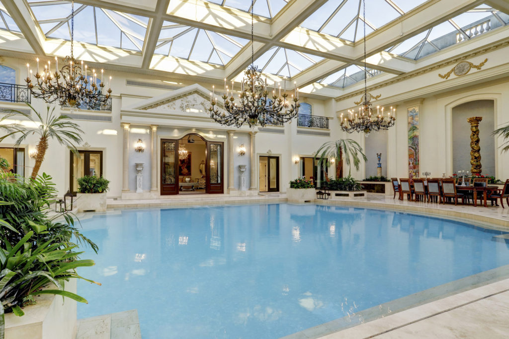 Three vast chandeliers sparkle above swimming pool in the former home of the late Baron Ricky di Portanova. (Photo by TK Images)