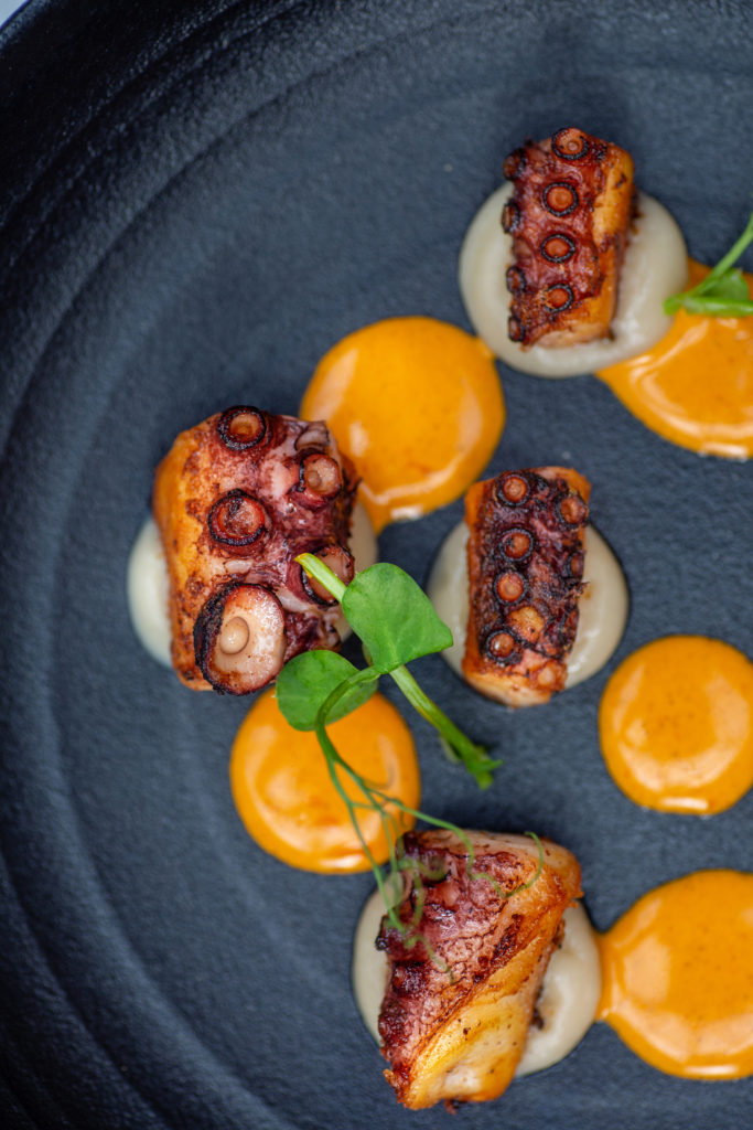 Appetizers at Villa Azur Dallas include King Crab, seared octopus, artichoke hearts, and more.