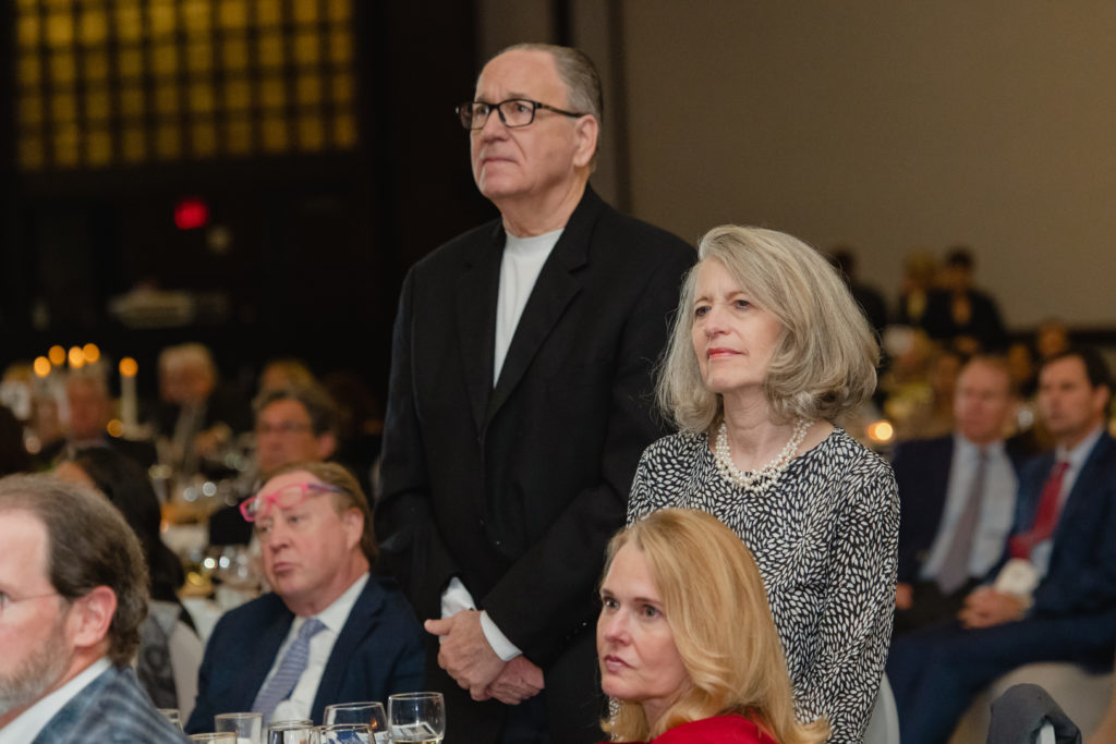 Surviving family members David Schwartz and Debbie Schwartz standing during a moment of honor for survivors at the Crime Stoppers of Houston gala. (Photo by CatchlightGroup.com)