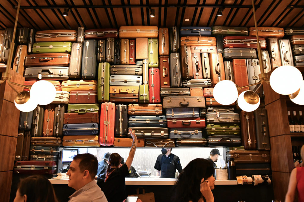 The artistic assembly of vintage suitcases at Postino in Uptown Park (Photo by Alex Montoya)