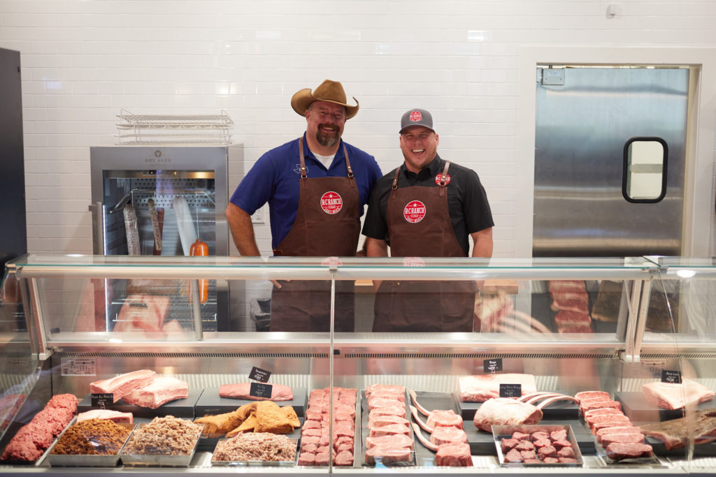 Co-owners, Ryan Cade and Blake Robertson behind the meat case at their new R-C Ranch Butcher Shop at the Houston Farmer's Market. (Photo Jody Horton)