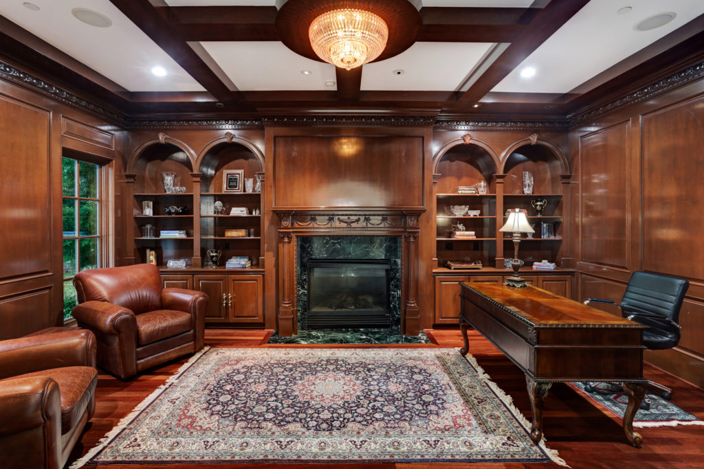 The paneled library at 6 Pine Tree lane features and Old World style fireplace. (Photo by TK Images)