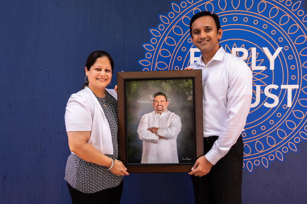 Shubhangi and Neelesh Musale hold a portrait of Shubhangi's brother, Mahesh who is the inspiration and namesake of their new Indian eatery, Mahesh's Kitchen. Photo by Michael Anthony.