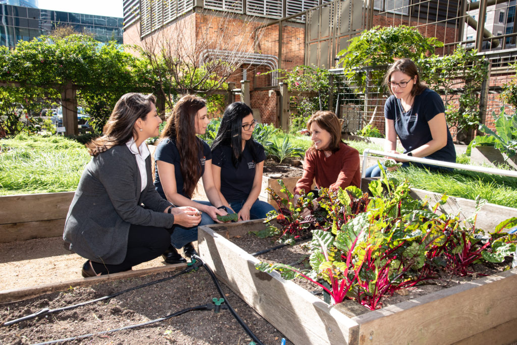 Laura Moore, director of the Nourish Program at UTHealth School of Public Health with students in the program's holistic garden. (Photo by Alexander's Fine Portrait Design)
