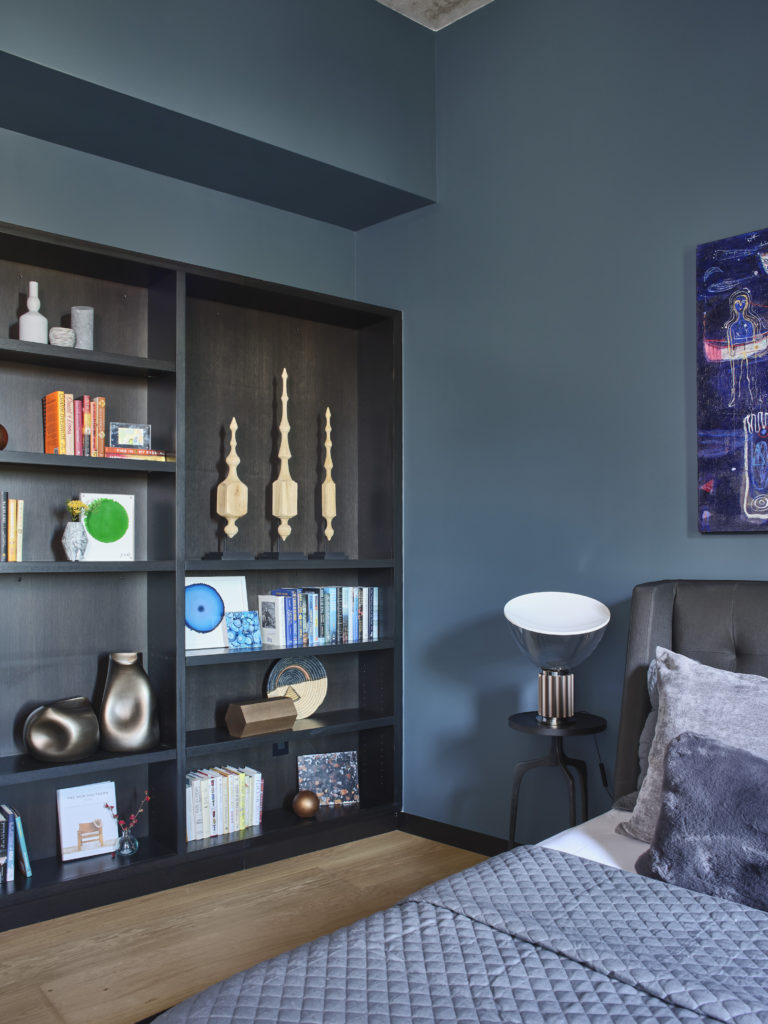 Various original artworks by John David Robbins add pops of color to the dark shelf design.