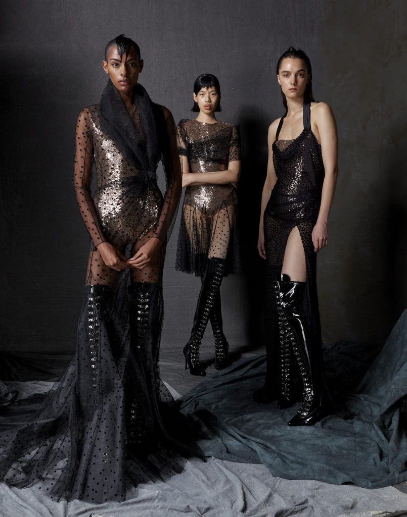 From left, Bach Mai black patchwork flocked tulle and lace shawl collar draped godet gown and black sequin bodysuit, black flocked dot tulle draped shawl neck godet dress with blush sequin bodysuit, black dot jacquard velvet draped bias gown silk satin halt strap with black sequin bodysuit. (Photo by Dimitri Hyacinthe)