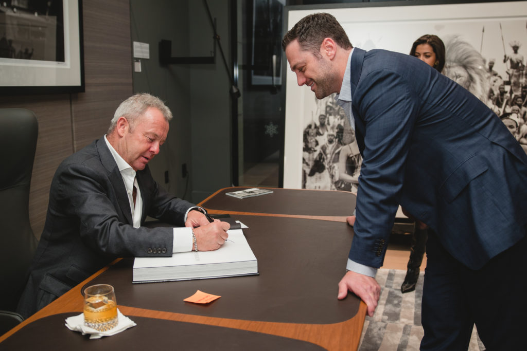 David Yarrow signs a volume for Dustan Gawthorp.  (Photo by Johnny Than )