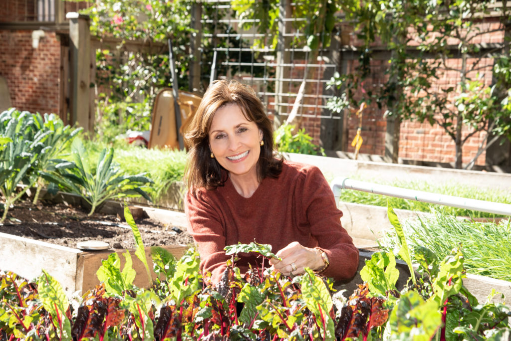 Nourish Laura S. Moore in the holistic garden that feeds UTHealth School of Public Health’s Nourish Program, the source of Moore’s book How Good Food Works From Seed to Table. (Photo by Alexander’s Fine Portrait Design)