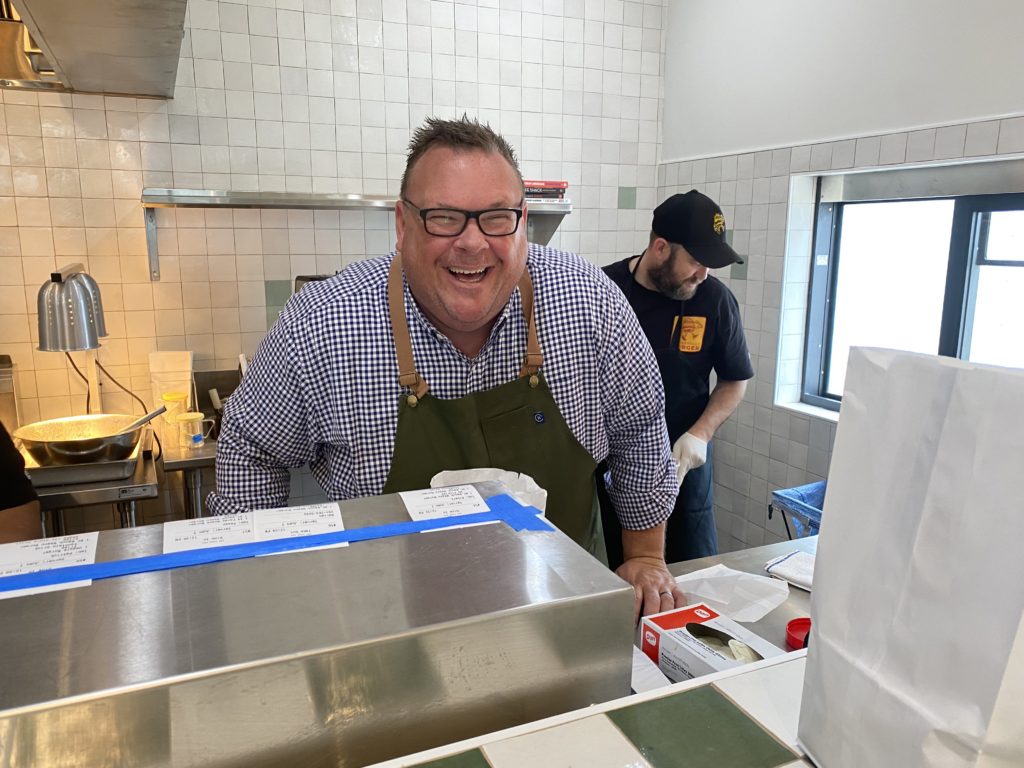 Chef Chris Shepherd shares a smile on the second day of service at his Underbelly Burger joint at Houston Farmers Market where the fans are already pouring in. (Photo by Shelby Hodge)