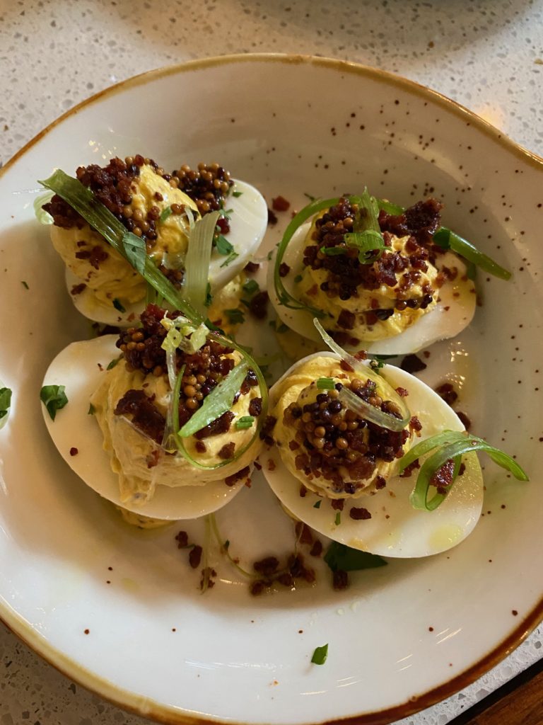 Yes, to Daily Gather's deviled eggs: a seeded mustard-egg yolk filling with tabasco-bacon crumble, green onion, and smoky salt. (Photo by Shelby Hodge)