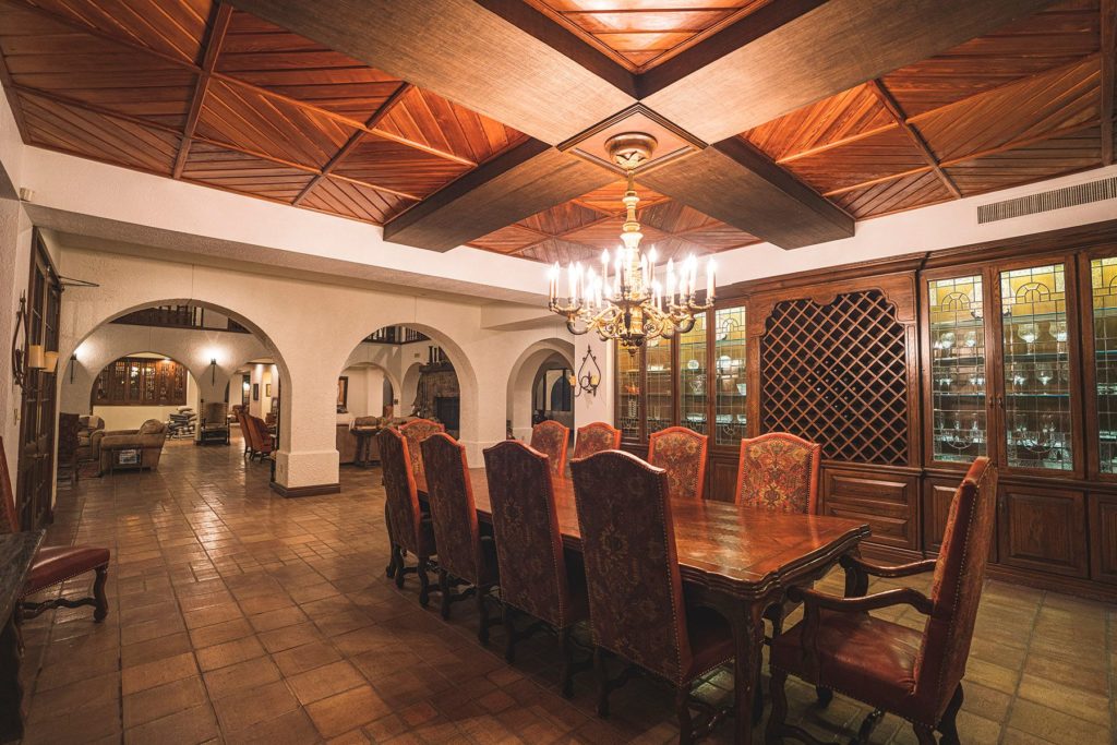 The formal dining room at Crawford Ranch opens to the Great Room via stucco arches.
