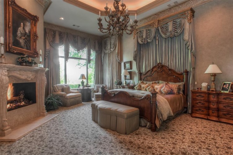 The main bedroom with opulent, regal canopy and carved marble fireplace.