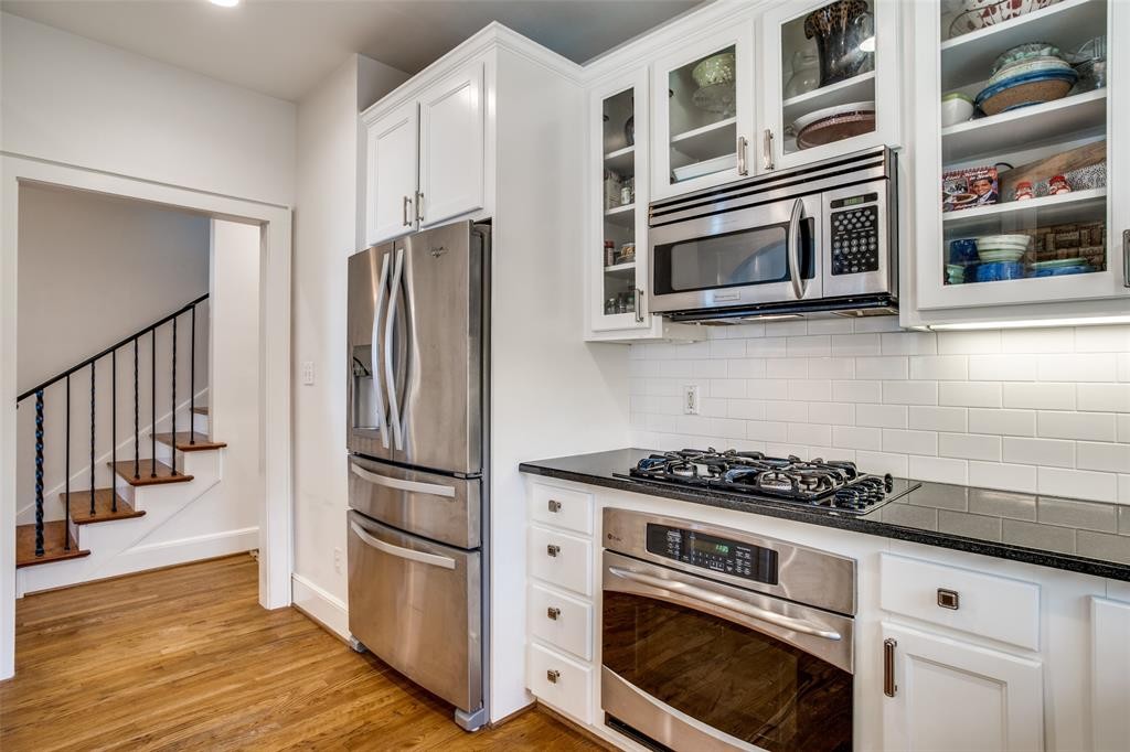The fully updated kitchen features white cabinetry and slick stainless appliances. 