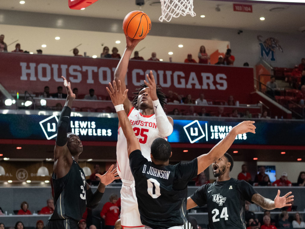 UH center Josh Carlton does not let a crowd stop him from scoring. (Photo by F. Carter Smith)