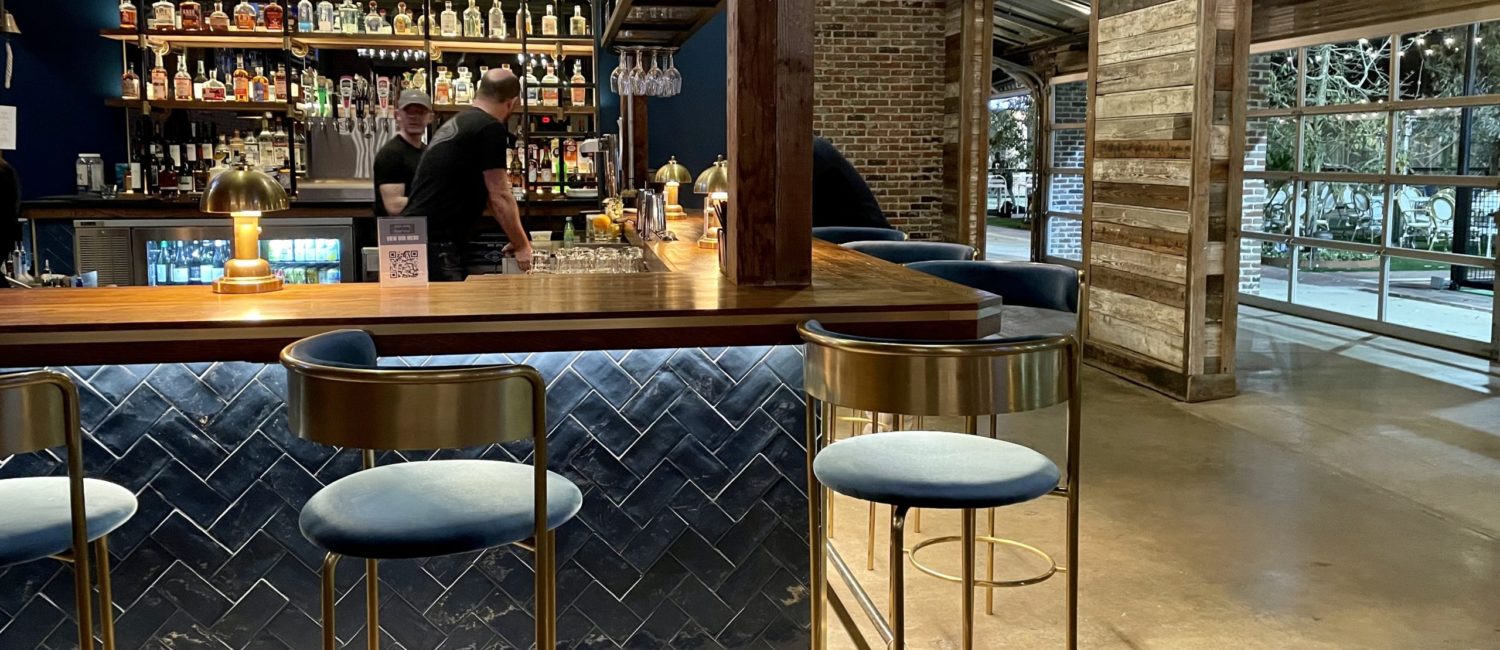 Courtside – Bar area opens onto lush patio and pickleball courts. Photo by Courtney Dabney.