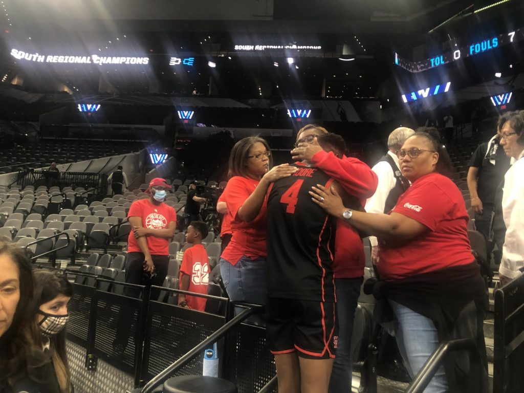 A crying Taze Moore is wrapped in a hug by his mom after Houston's Elite Eight loss to Villanova. (Photo by Chris Baldwin)