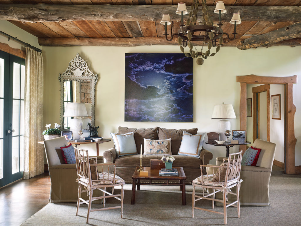 In the main living area, a door is framed by natural- edge oak, repurposed from an old barn. Furnishings include a mix of English antiques and vintage Round Top finds. Artwork by Damian Loeb from Acquavella Galleries, New York. (Photo by Tria Giovan)