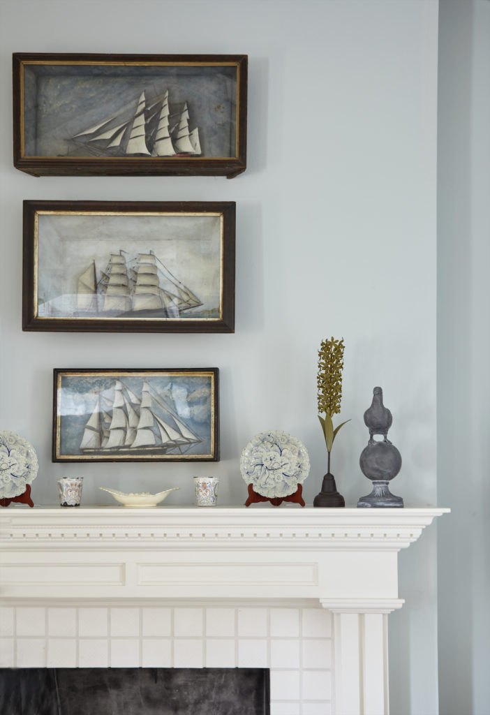 The cottage faces a lake, so a collection of ship dioramas adds a nautical touch. (Photo by Tria Giovan)