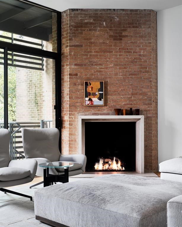A brick wall brings warmth (and a fireplace) to the upstairs living area. 
