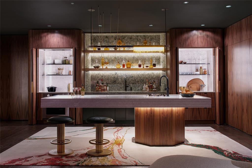 Also in the basement, a fully functional kitchen features sleek fixtures and appliances by Kohler and Signature Kitchen Suite, custom cabinetry by Helene’s Luxury Kitchen, and a delicate fixture by Wired Custom Lighting. (Photo by Costa Christ Media)