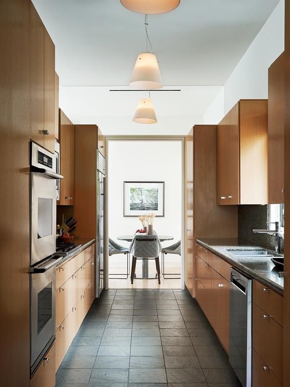 Concrete floors contrast with white oak cabinetry in the intimate kitchen. 