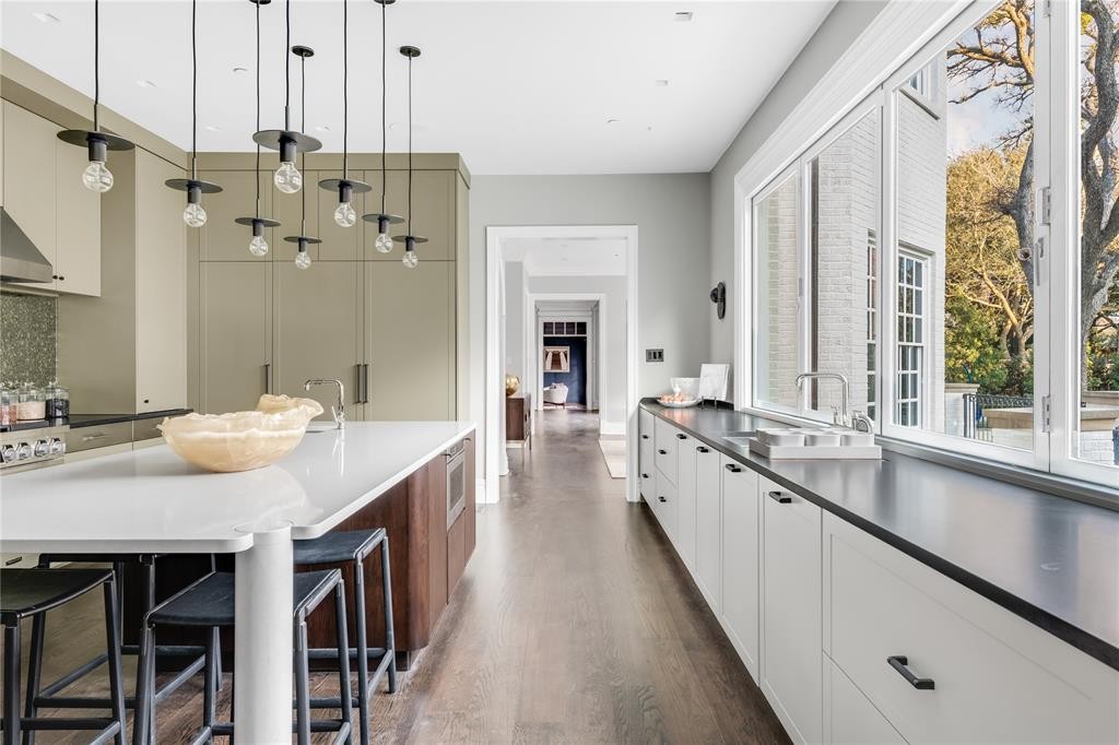 Studio 6F’s fern green cabinetry remains in the kitchen, as well as the custom Cambria quartz island. (Photo by Costa Christ Media)