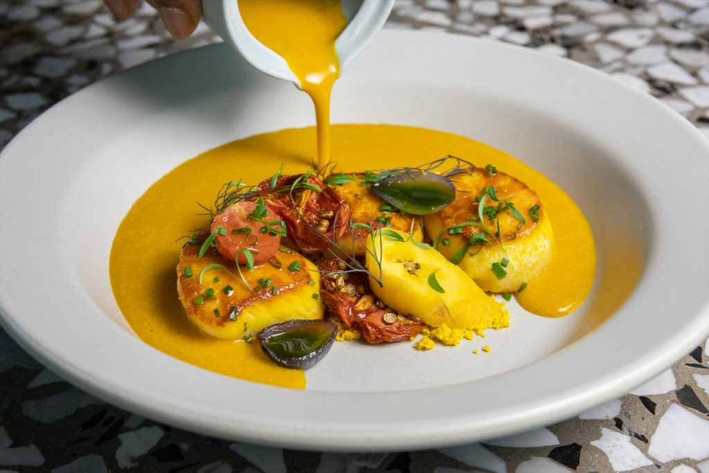 Sea Scallop Moqueca with charred plantain and coconut broth, dende oil and steamed rice at Meridian.