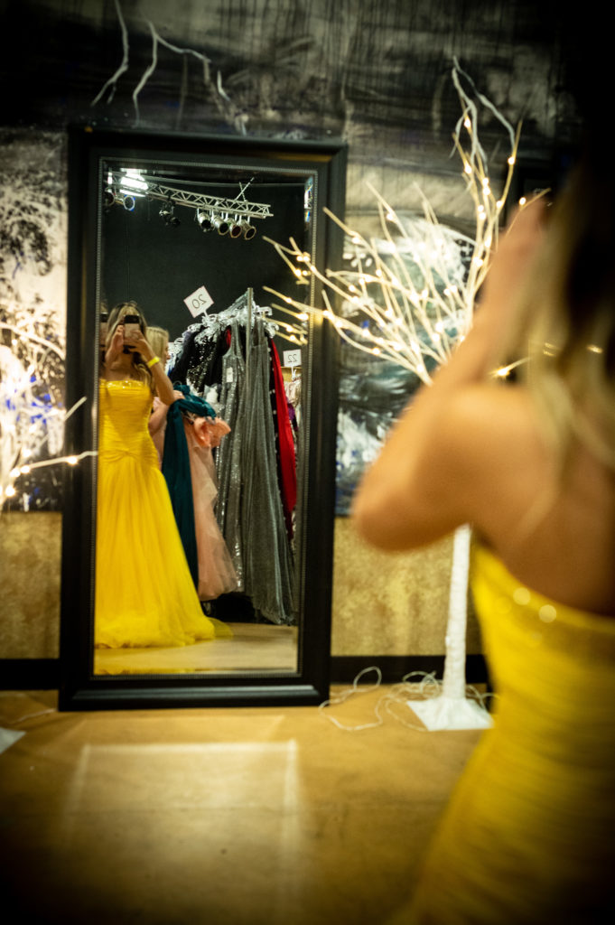This teenager snaps a photo of herself in a strapless yellow gown she has selected for her prom. (Photo by Sara Blair Design Photography)