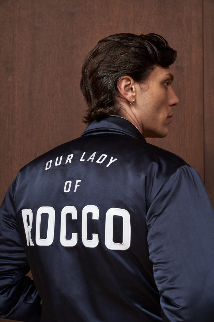 The navy satin bomber jacket features “Our Lady of Rocco” embroidered on the back. ($595) 