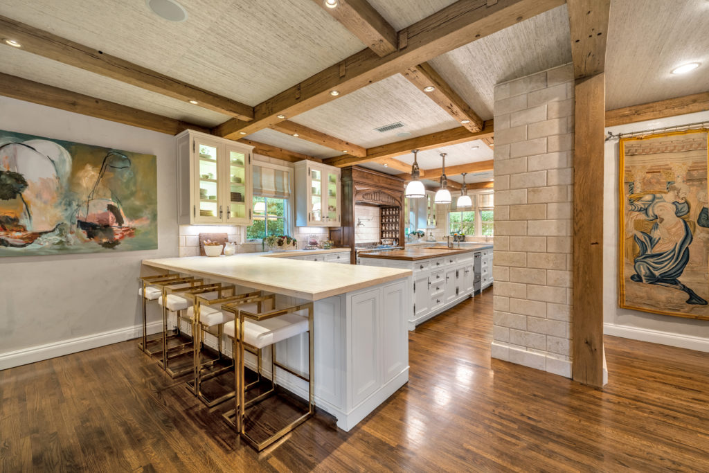 Old World beams and hood accents mix with modern bar seating overlooking the kitchen.