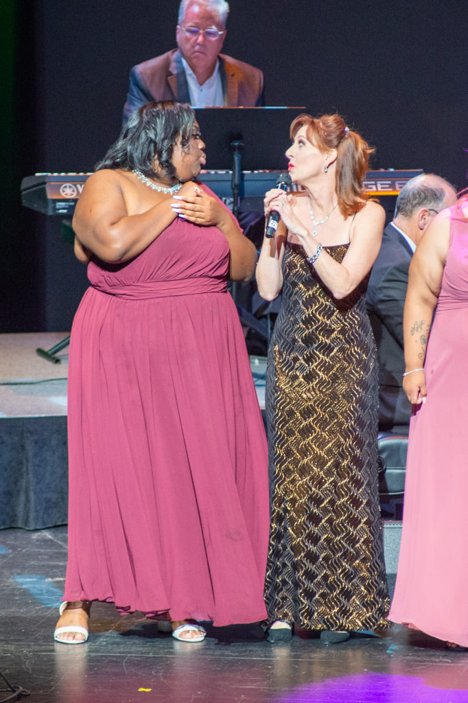 Rita Harvey and CHT youth resident Kenecia singing along to 'Don’t Stop Believing' at Covenant House Texas Night of Broadway Stars