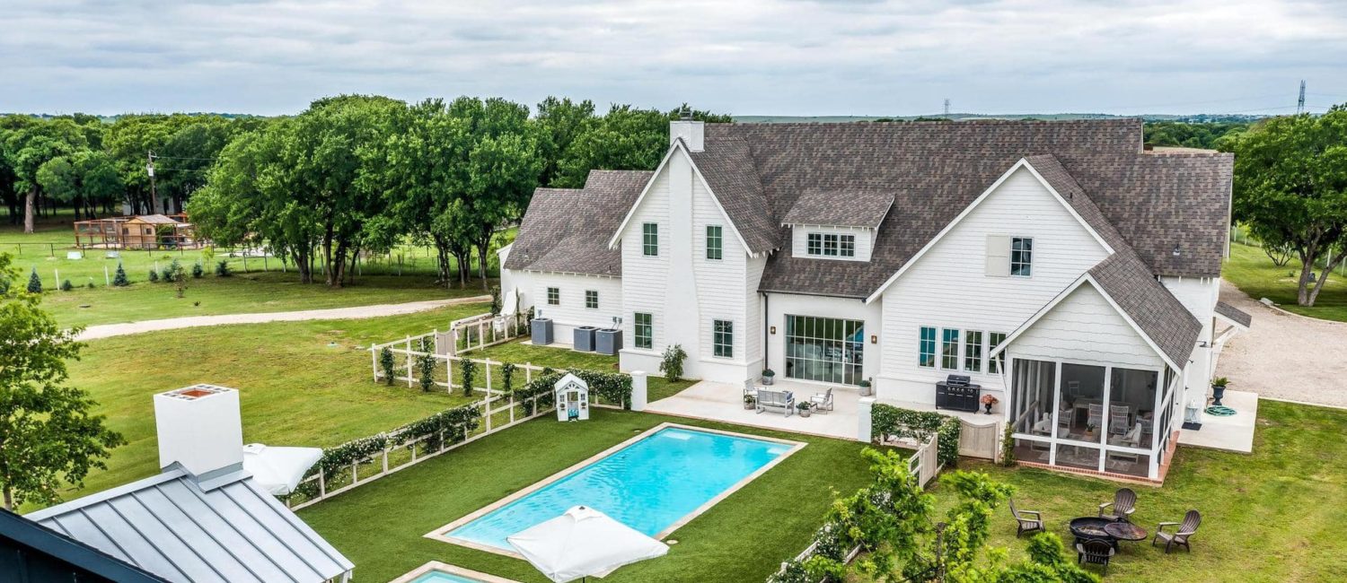 This Fort Worth dream home is a  Hampton’s style estate with a view across the pool to the main house.
