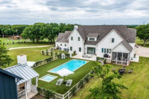 This Fort Worth dream home is a  Hampton’s style estate with a view across the pool to the main house.