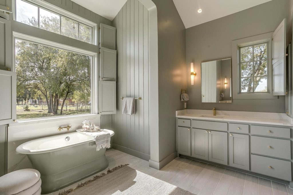 Sage green primary bath with soaking tub, shower and dual vanities.