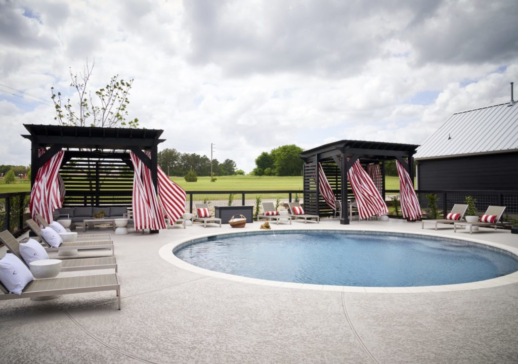 The glamorous round pool and striped cabanas.