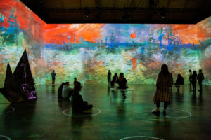 Onlookers take in a serene painting at "Immersive Monet & The Impressionists." (Photo by Patrick Hodgon)