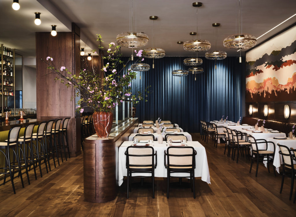 The Sassetta dining room, featuring a showstopping de Gournay mural and pendants by Gallotti & Radice. (Photo by Douglas Friedman)
