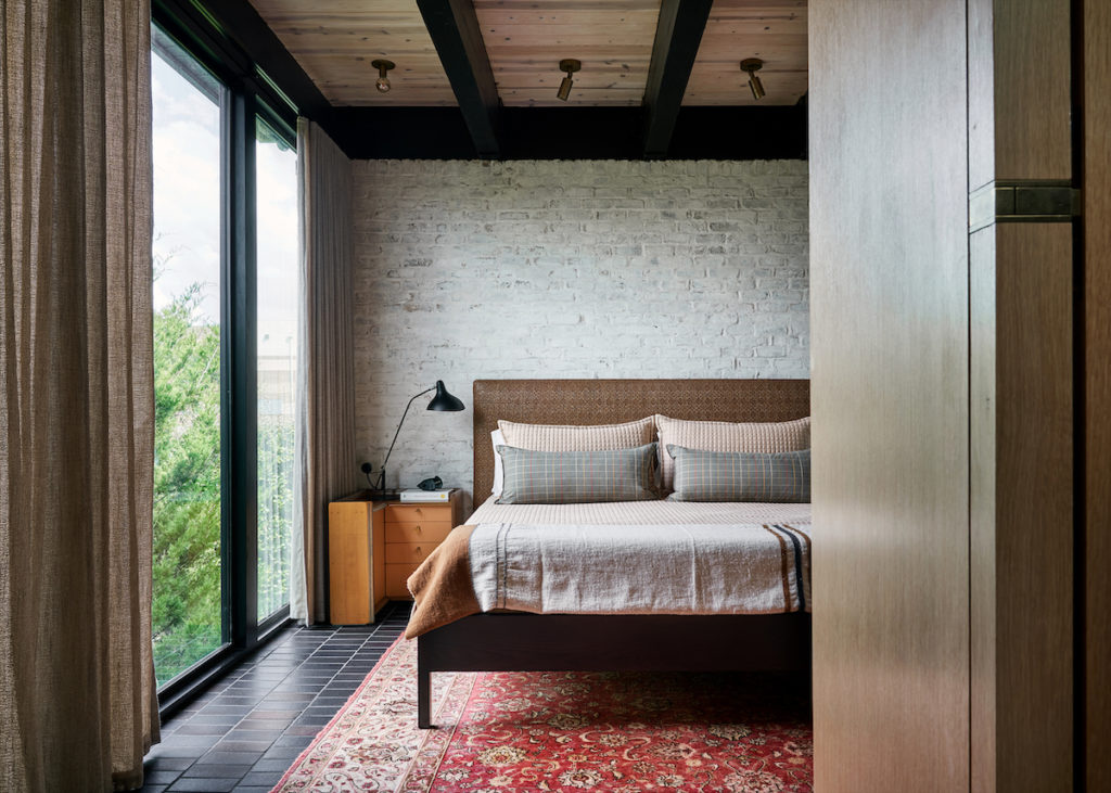 In the main bedroom, one of a pair of rare Afra and Tobia Scarpa nightstands designed for Maxalto. Bernard Schottlander lamp. Verellen bed upholstered in Ralph Lauren raffia. Blanket by Libeco, Sweden. (Photo by Stephen Karlisch and Robert Tsai)