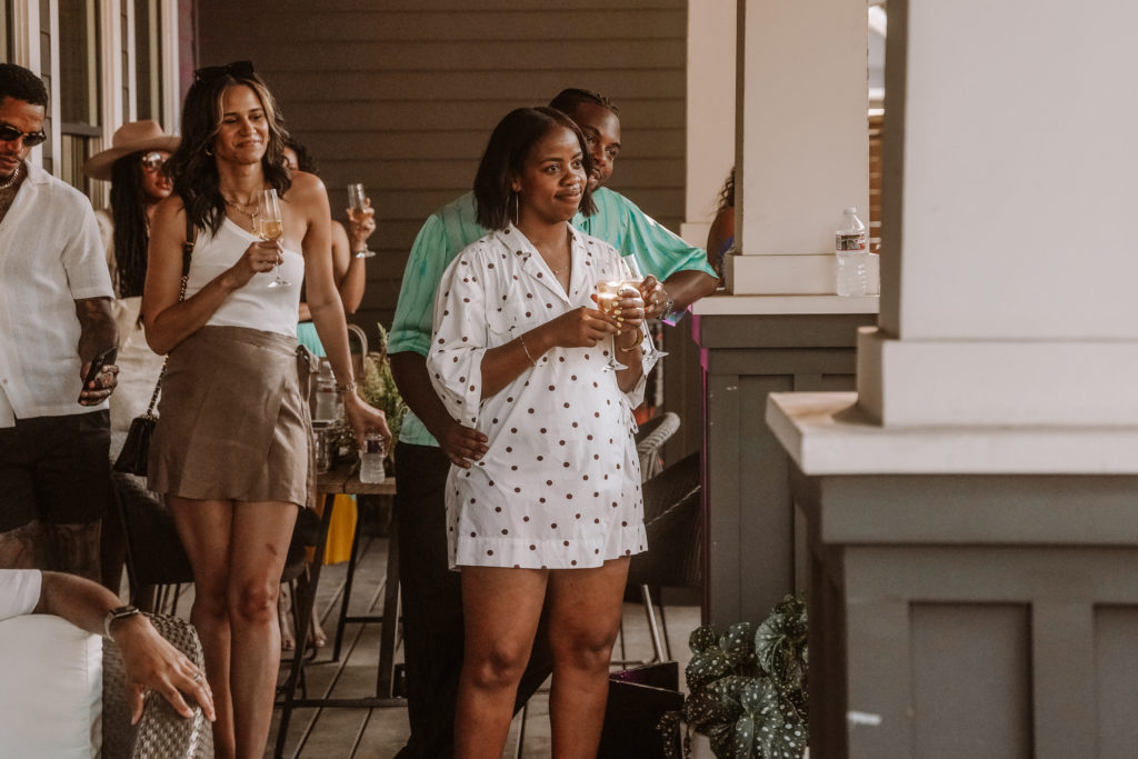 Guests gather on the porch to take in Kevin Barnett's remarks. Foreground, hosts Terri and Troy Hamm. (Photo by William Issac)