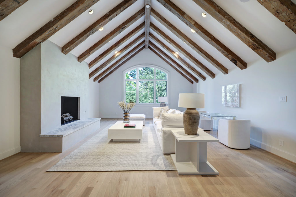 The second floor family room at 402 Timberwilde is accented with 100 year old beams. (Photo by TK Images)