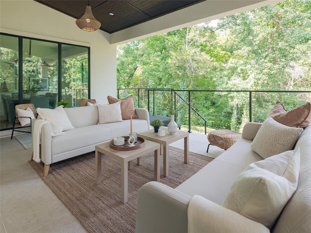 A covered porch looks out upon serene natural surroundings. 