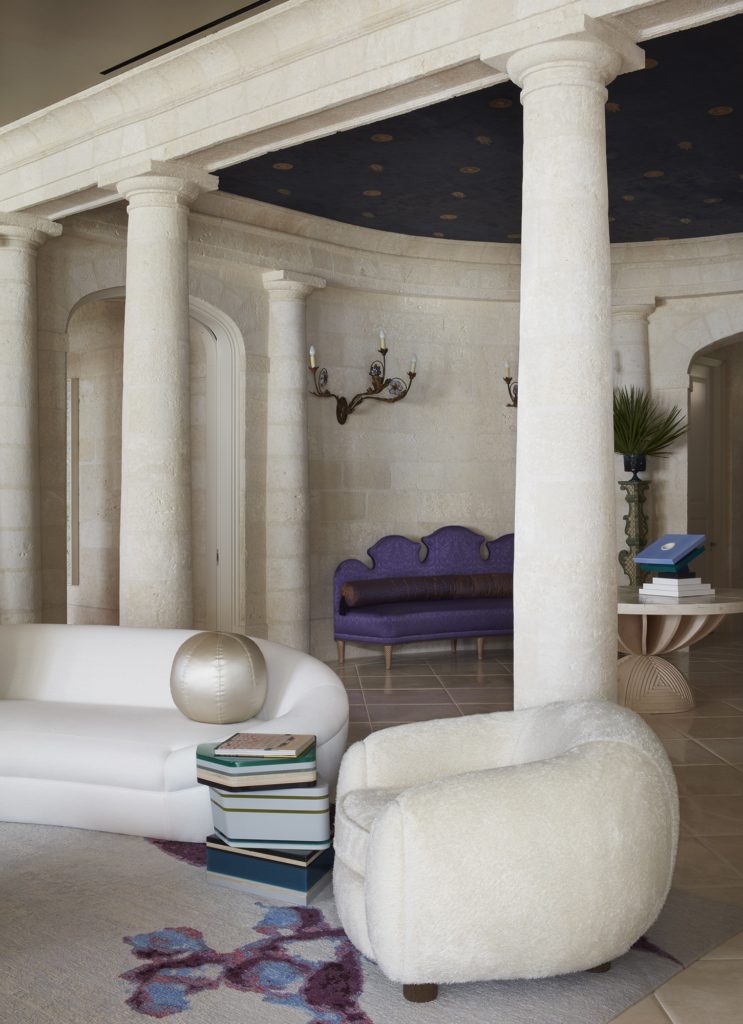 In a Naples, Florida, house designed by Stephen Sills, a column screen divides the semicircular entrance hall, purposely kept dark with its midnight-blue–painted ceiling, from the lightness and playfulness of the living room. (Photo by Simon Upton)