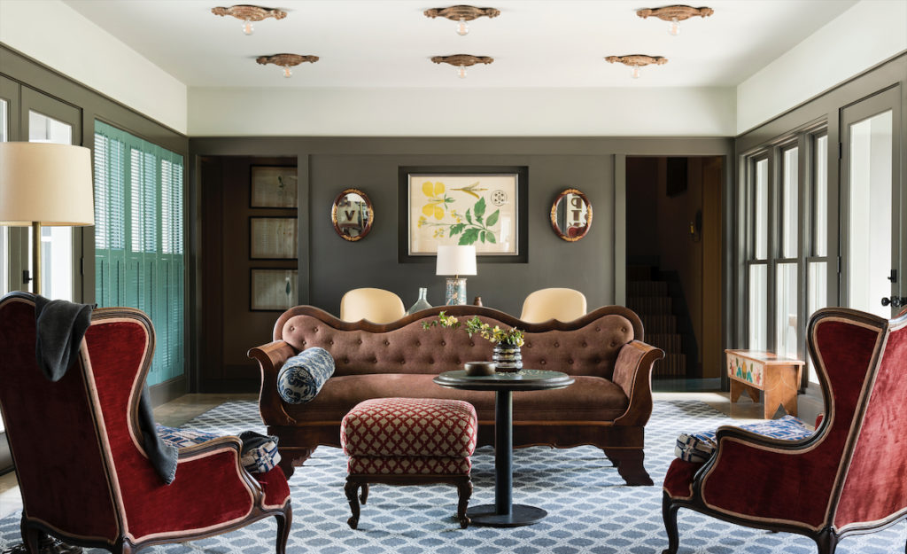 The living area’s Victorian sofa is one of a pair Jill Brown inherited from her husband’s family. The antique, red-velvet Belgian chairs have seat cushions covered in gently frayed fabric that belonged to her husband’s mother. Antique bench painted by folk artist Lew Hudnall belonged to Brown’s mother. Antique ceiling fixtures from Brown House & Wares. (Photo by Jack Thompson)