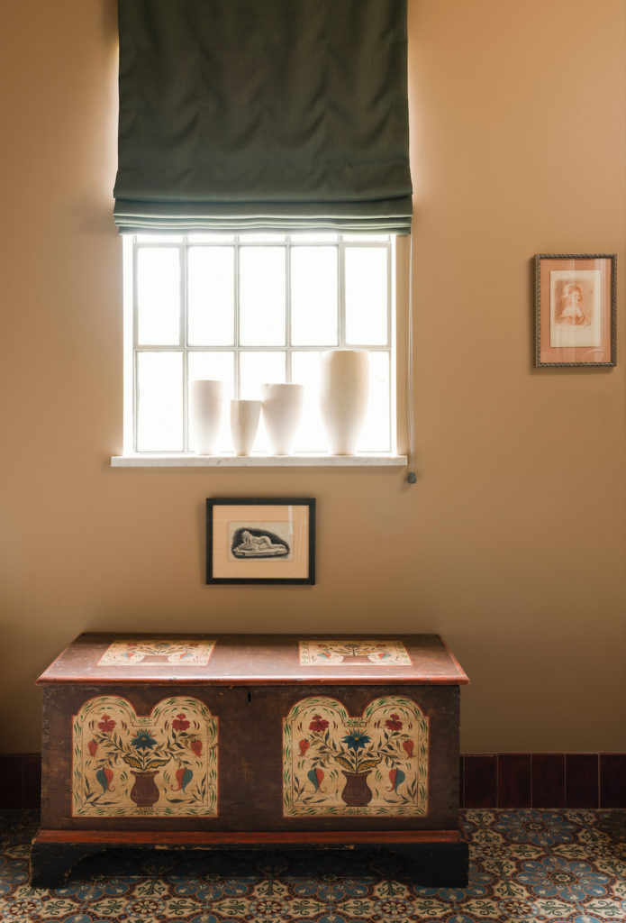 Antique painted chest by Lew Hudnall. White vases made for Goyard in Paris. Antique iron window from Belgium. (Photo by Jack Thompson)