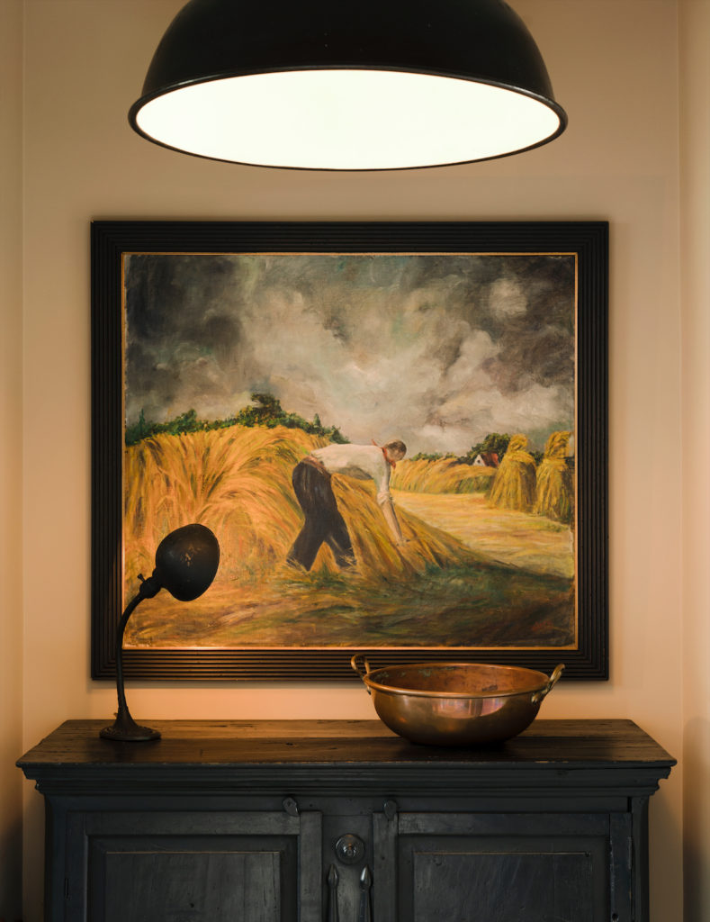 A painting in the foyer purchased in Belgium echoes the straw-colored walls. (Photo by Jack Thompson)
