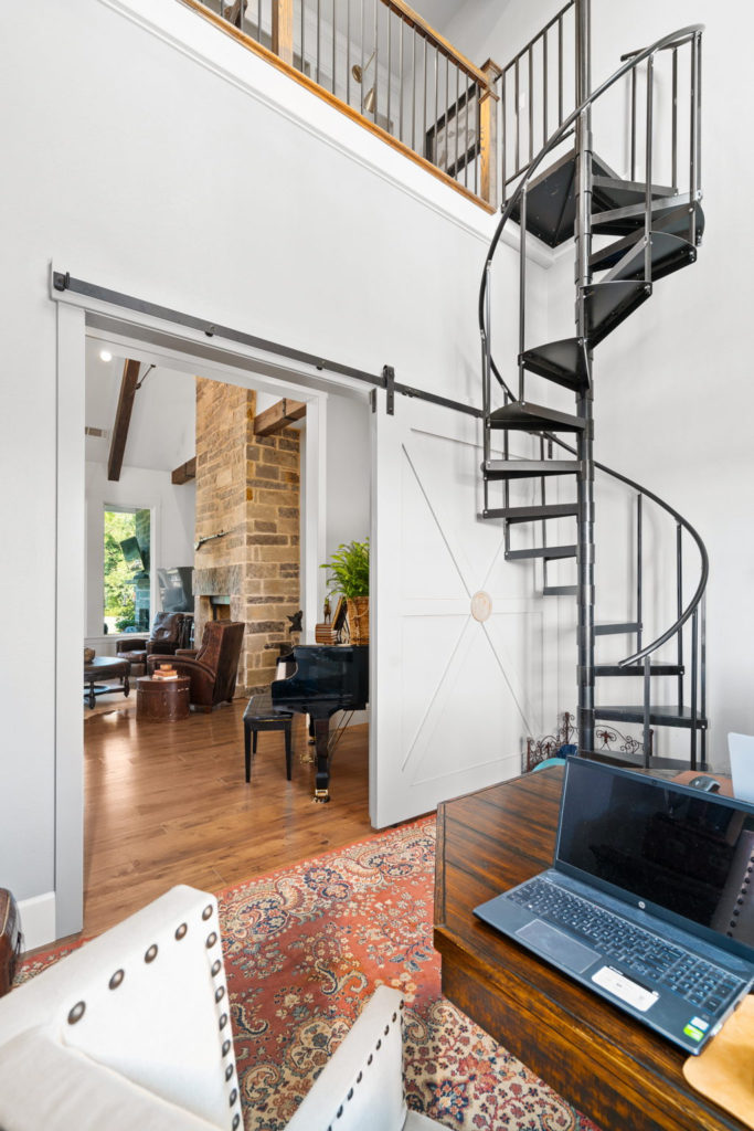 A rustic, spiral staircase takes you to the main home's second floor. (Photo by Sharp Frame Media for Douglas Elliman Realty)